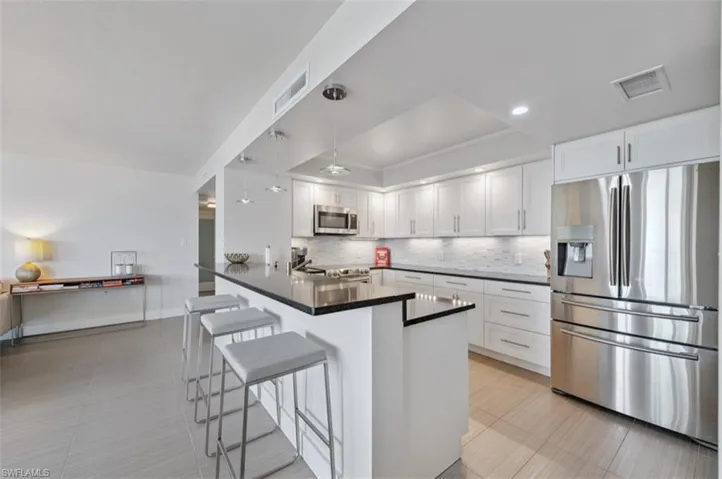 Kitchen with stainless steel refrigerator with ice dispenser