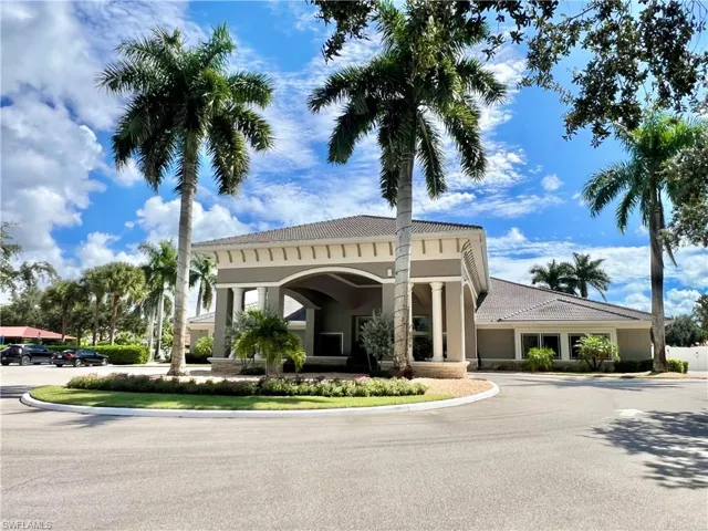 Entrance with a portico featuring columns, tile roof, and a circular driveway