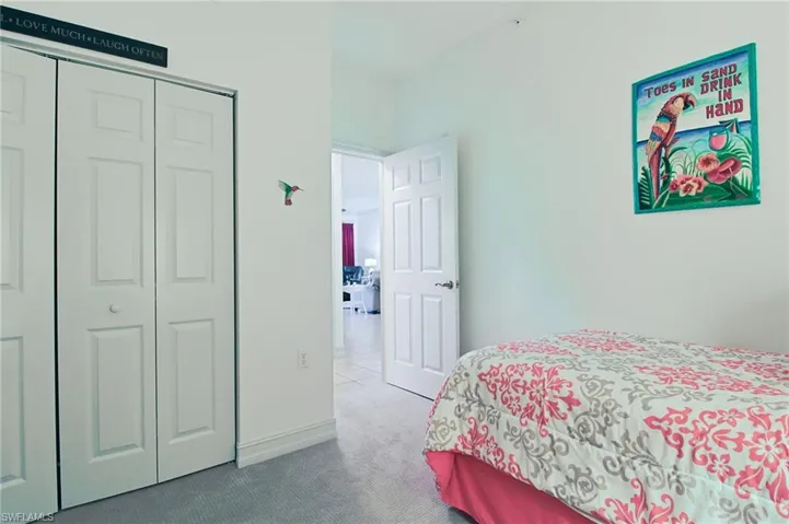 Carpeted bedroom featuring baseboards and a closet