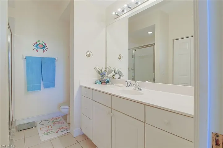 Bathroom with toilet, tile patterned floors, a shower stall, and vanity