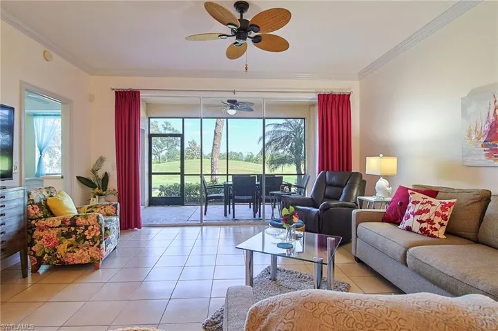 Living room featuring crown molding, a ceiling fan, and light tile patterned floors