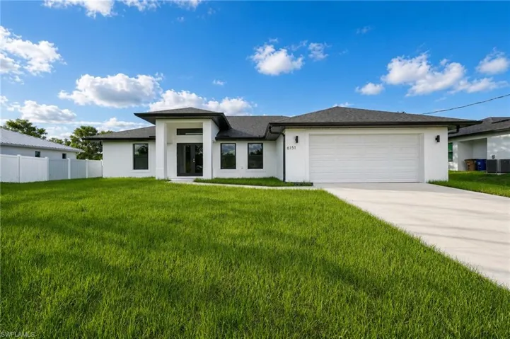 Contemporary exterior with white stucco finish, dark framed windows, a two-car garage, and a concrete driveway