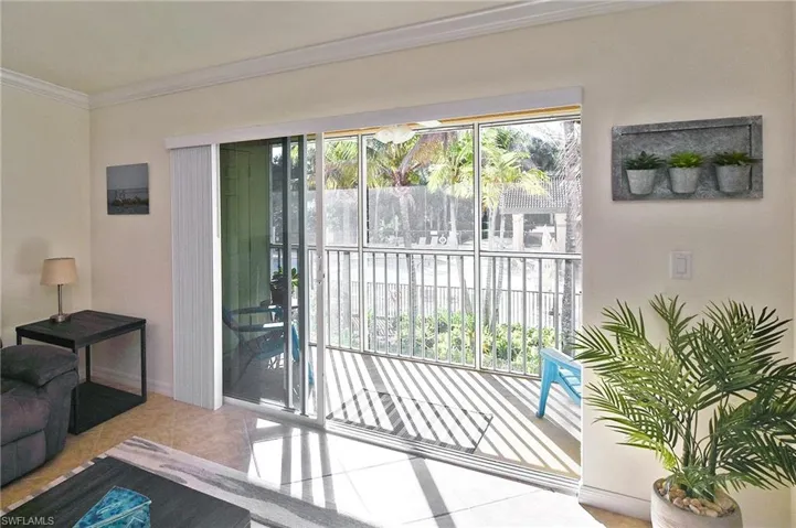 Doorway to outside featuring ornamental molding, plenty of natural light, and tile patterned flooring