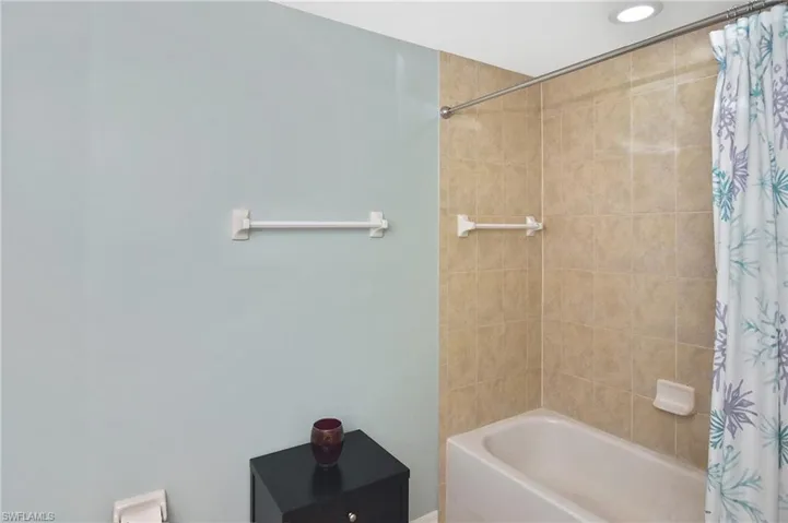 Full bathroom featuring shower / bathtub combination with curtain