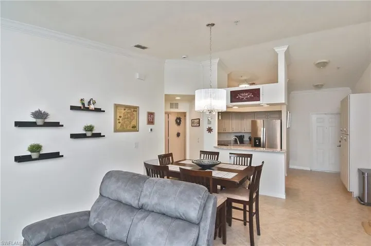 Dining space featuring ornamental molding, a chandelier, and a high ceiling
