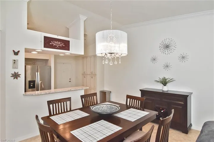 Dining room with suspended lighting and crown molding