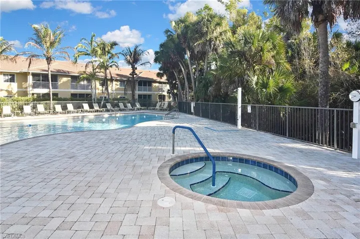Community pool with a patio area and a hot tub