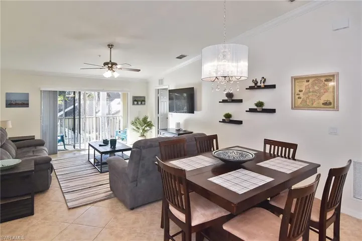 Dining area with ornamental molding, a ceiling fan, hanging lights, and light tile patterned flooring