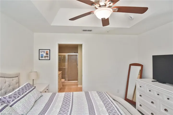 Bedroom featuring ceiling fan and ensuite bathroom