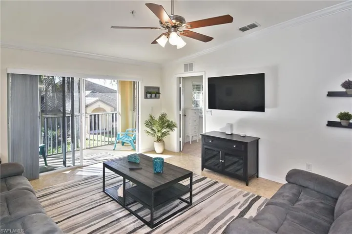 Living room with crown molding and a ceiling fan