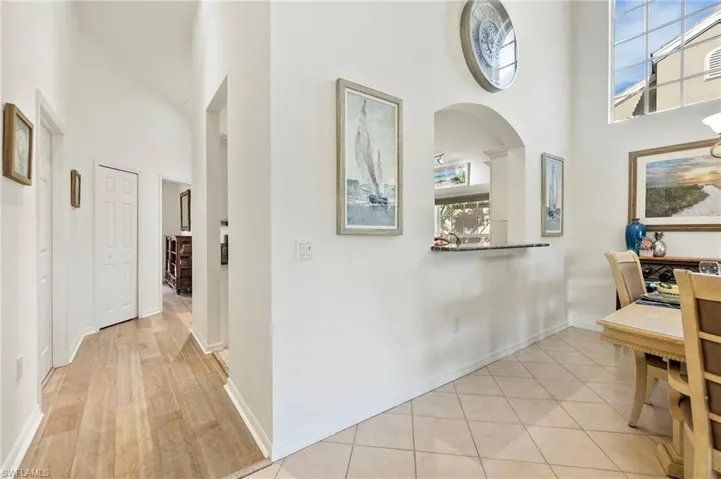 Hallway with a towering ceiling and light tile patterned floors