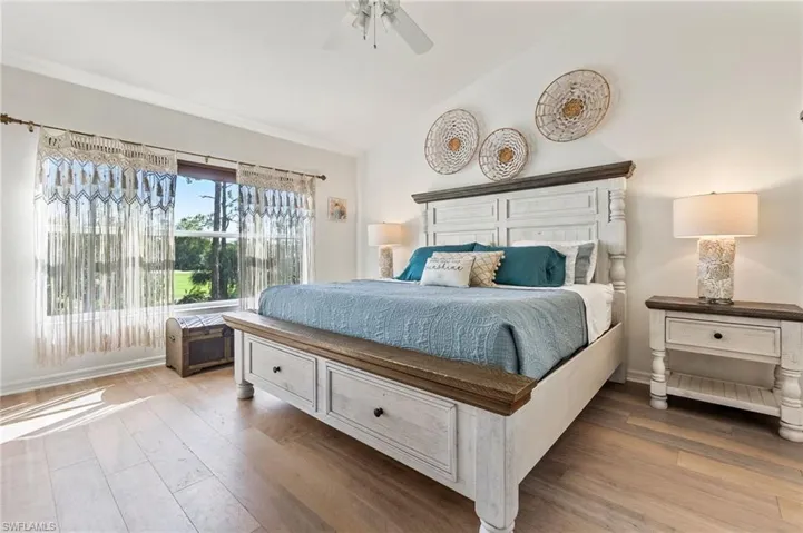 Bedroom with vaulted ceiling, light wood-style flooring, and ceiling fan