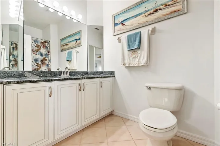 Bathroom featuring light tile patterned flooring, a shower with curtain, and vanity