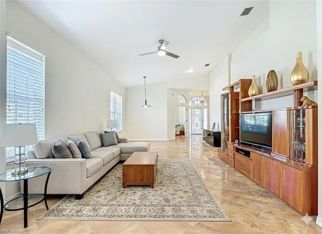 Living area featuring ceiling fan and lofted ceiling