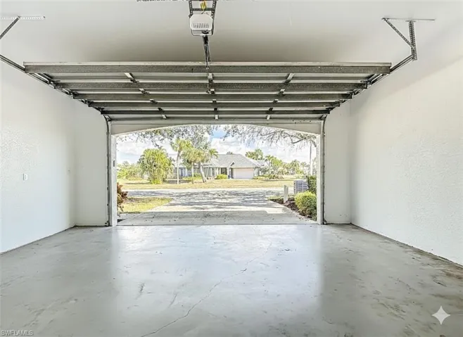 Garage featuring a textured wall and a garage door opener