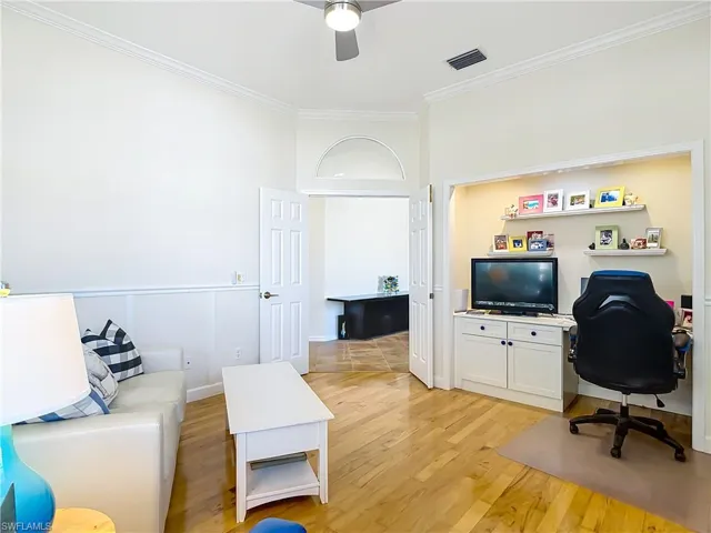 3rd bedroom featuring light wood-style flooring, ornamental molding, and a ceiling fan