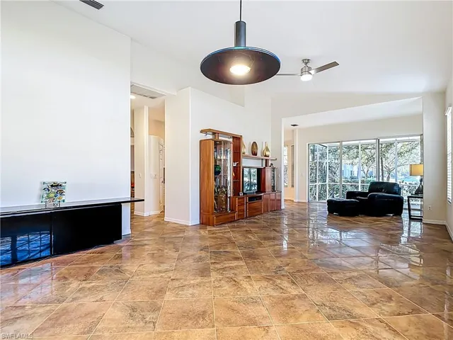 Living area with a ceiling fan and a high ceiling