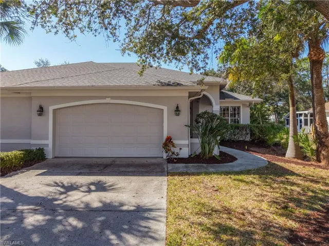 Ranch-style home featuring a shingled roof, stucco siding, driveway, an attached garage, and a front yard