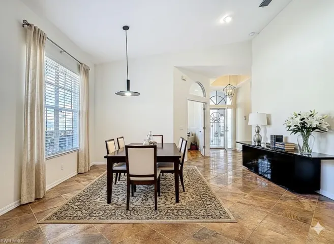 Dining area featuring baseboards and a high ceiling