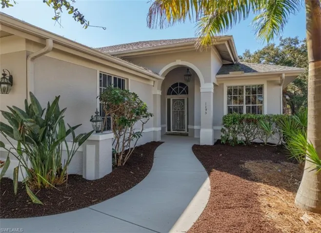 Property entrance with stucco siding and roof with shingles