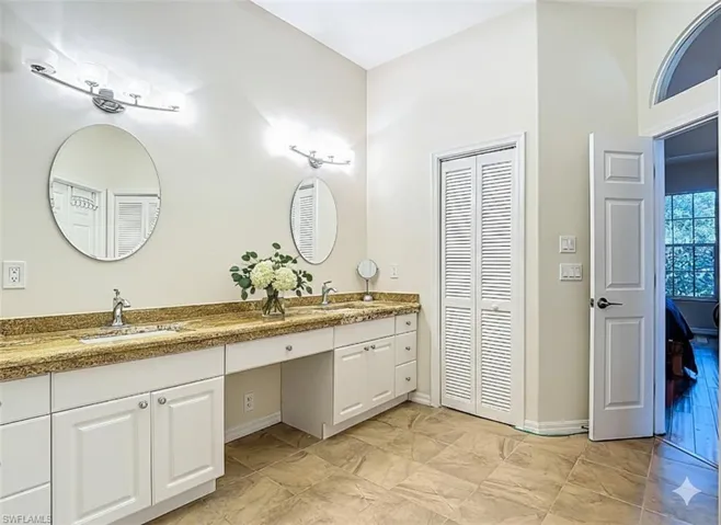Bathroom featuring a closet and double vanity