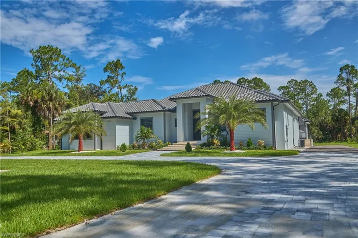 Mediterranean / spanish-style home featuring a garage and a front yard