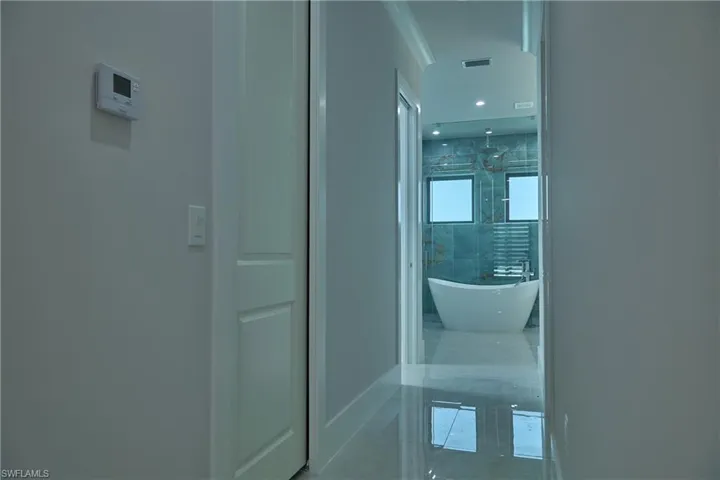 Hall with tile patterned flooring and ornamental molding