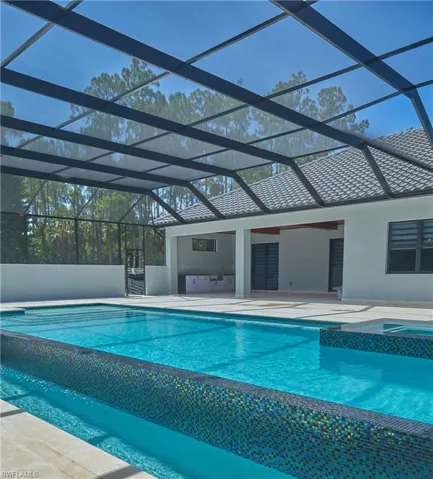 View of swimming pool with a patio and glass enclosure