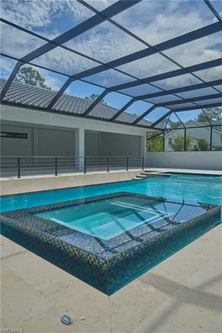 View of pool with a patio, an in ground hot tub, and a lanai