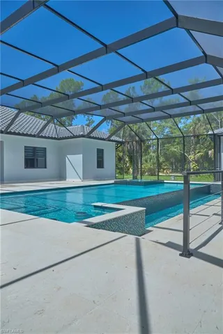 View of swimming pool featuring a patio area and a lanai