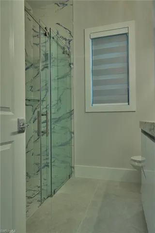 Bathroom with vanity, toilet, a shower with door, and tile patterned floors