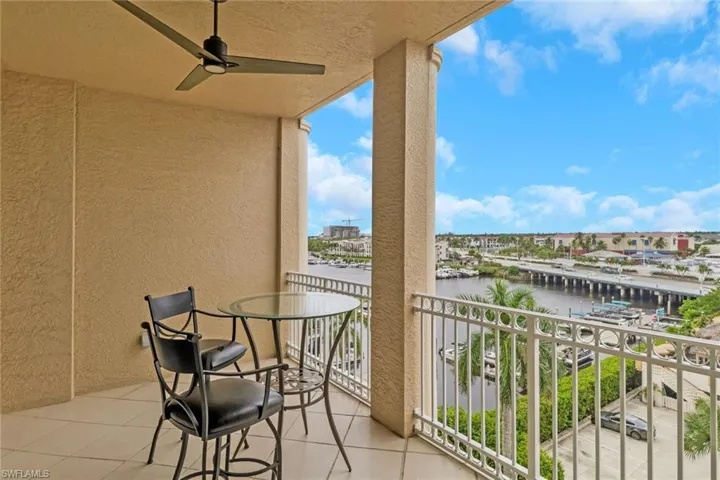 Balcony featuring ceiling fan, a sunroom, and a water view