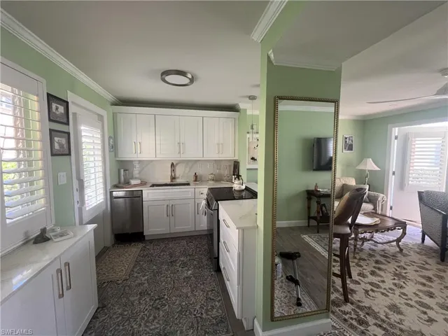 Kitchen featuring white shaker-style cabinetry, stainless steel appliances, a white countertop, and a tile backsplash