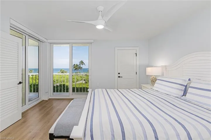 Bedroom with light hardwood / wood-style floors, multiple windows, a closet, and access to outside