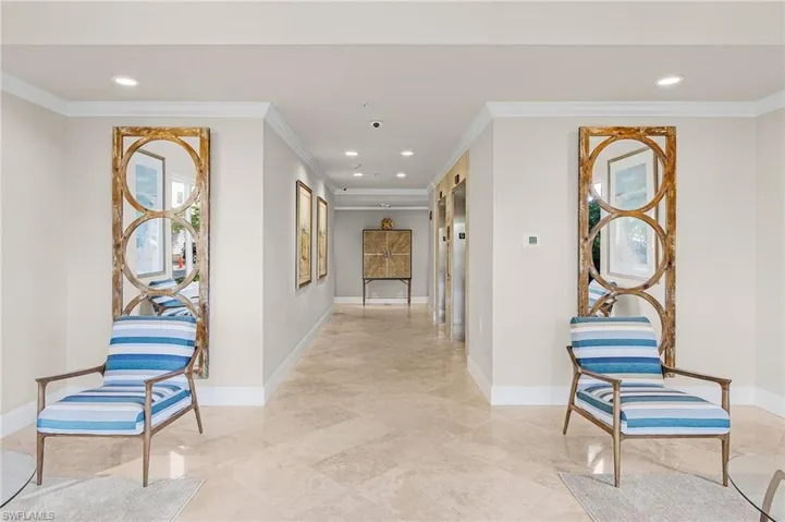 Hall with ornamental molding and light tile patterned flooring
