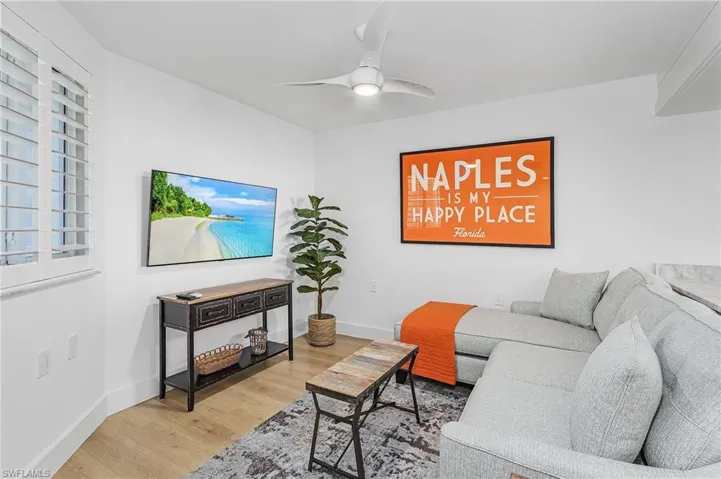 Living room with ceiling fan and hardwood / wood-style flooring