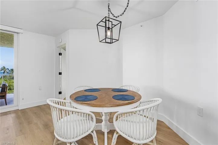 Dining room with light hardwood / wood-style floors and an inviting chandelier