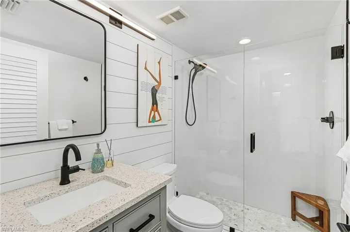 Bathroom with vanity, walk in shower, and toilet