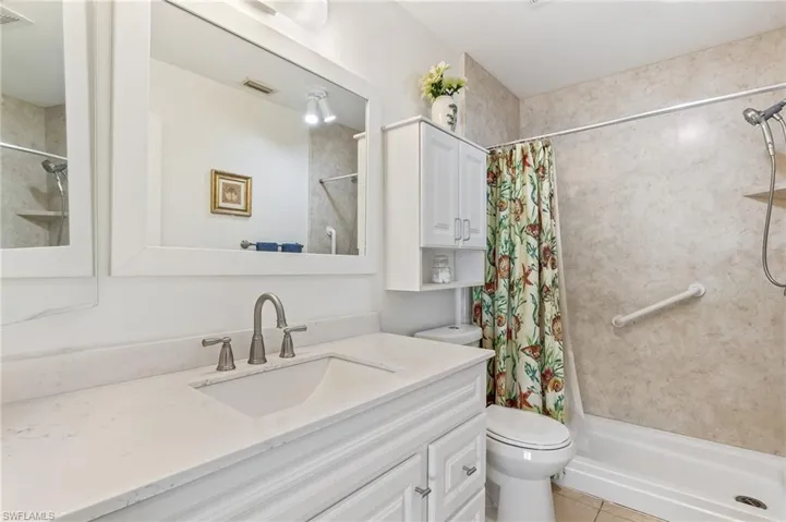 Bathroom with a stall shower, vanity, and light tile patterned flooring