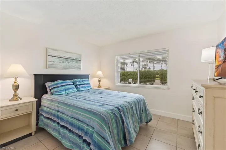 Bedroom with light tile patterned floors and a textured ceiling
