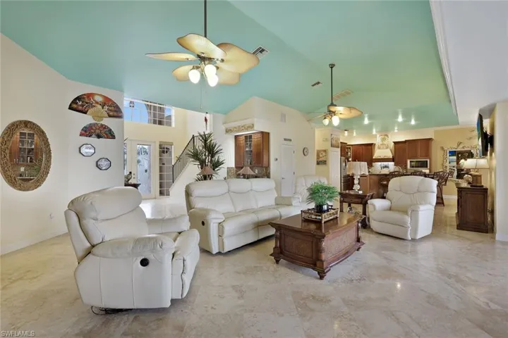 Vaulted ceilings with recessed lighting, tile flooring, and ceiling fans