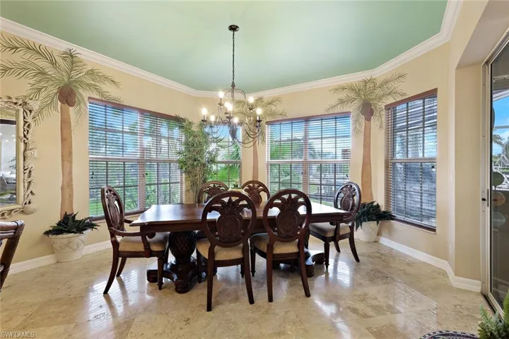 Recessed dining area featuring multiple windows with blinds, a multi-light chandelier