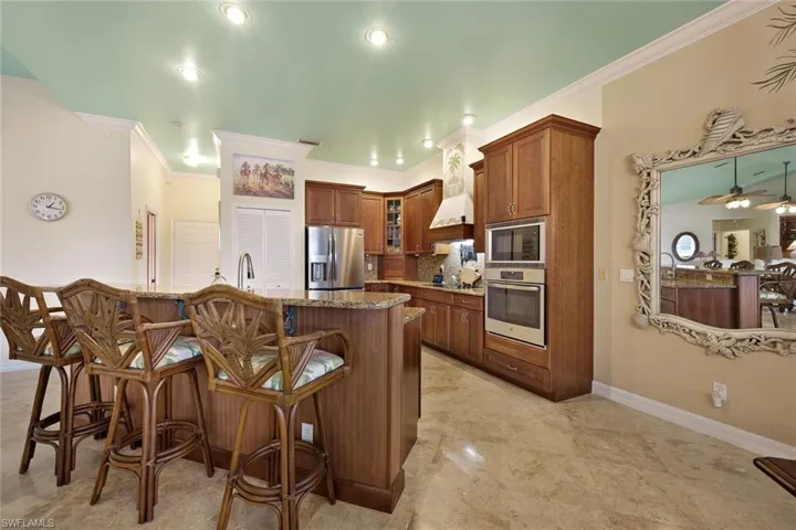 Spacious kitchen featuring granite countertops, wood cabinetry, stainless steel appliances, and recessed lighting
