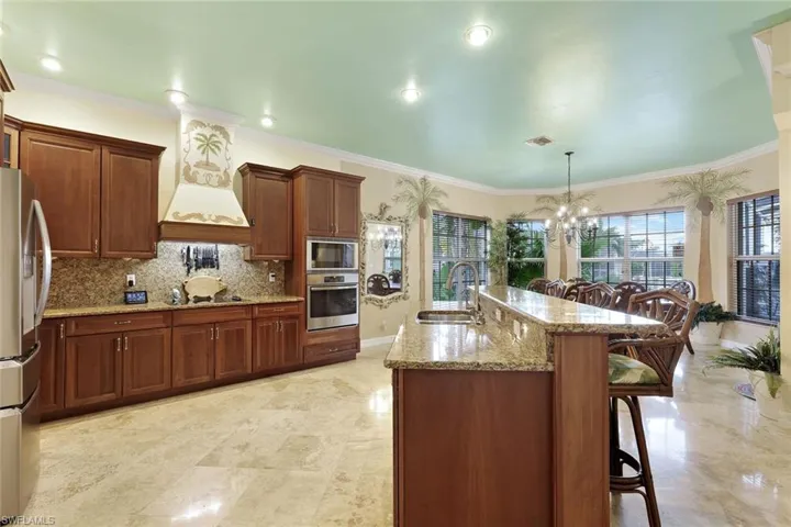 Spacious kitchen featuring granite countertops, wood cabinetry, stainless steel appliances, and recessed lighting