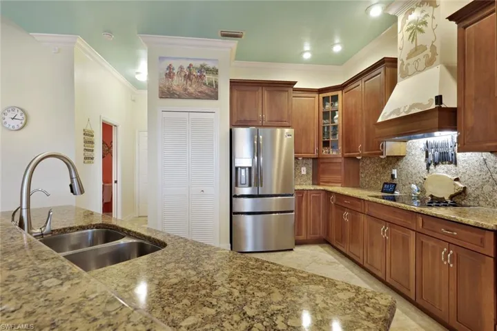 Spacious kitchen featuring granite countertops, wood cabinetry, stainless steel appliances, and recessed lighting