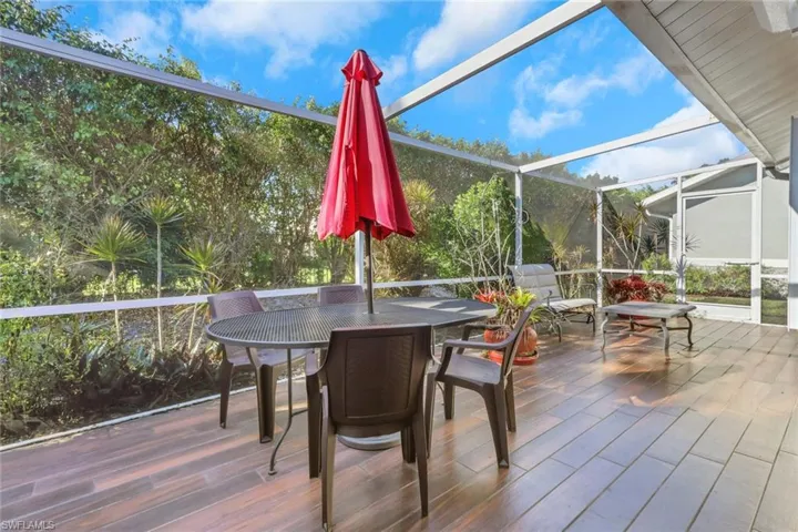 Wooden terrace featuring a sunroom, a lanai, and outdoor dining area