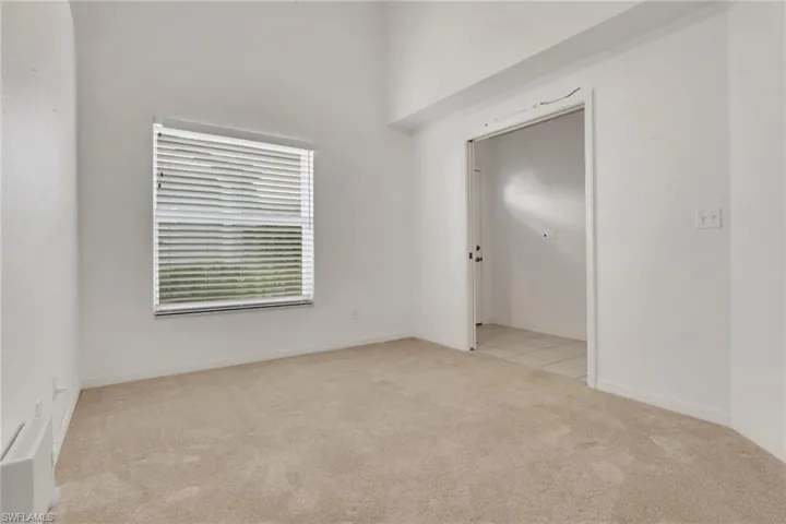Spare room featuring light colored carpet and baseboards