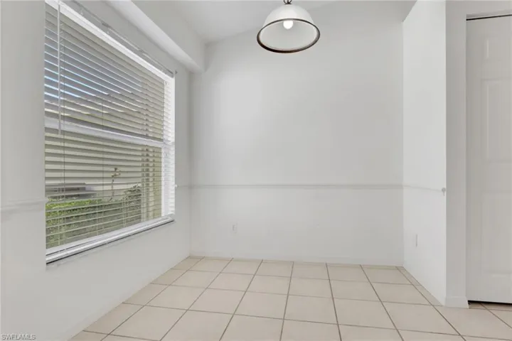 Unfurnished room featuring light tile patterned floors and baseboards