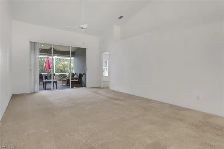 Carpeted spare room with high vaulted ceiling and ceiling fan