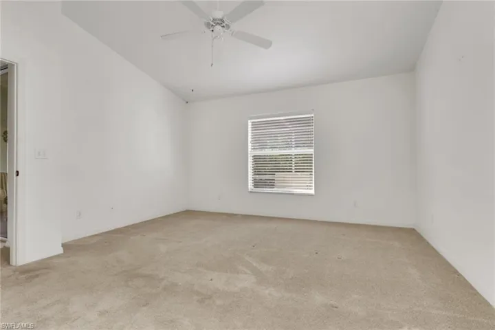 Unfurnished room with light colored carpet and ceiling fan